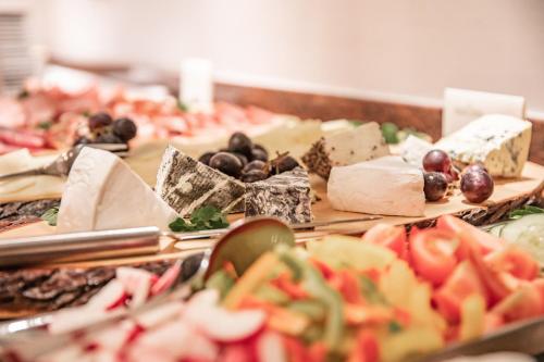 a bunch of different types of cheese and fruit on a buffet at Naturhotel Schloss Kassegg in Sankt Gallen
