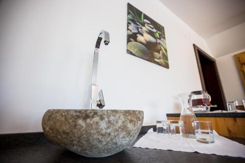 a bathroom with a large stone sink on a counter at Naturhotel Schloss Kassegg in Sankt Gallen
