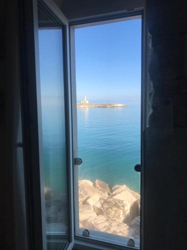 a view of the ocean from a window at Romeus al Fortino dimora sul mare in Vieste