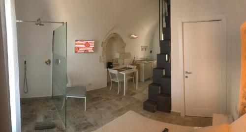 a bathroom with a shower and a table with chairs at Romeus al Fortino dimora sul mare in Vieste