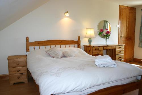 a bedroom with a bed and a dresser and a mirror at Garden Cottage in Prestwick