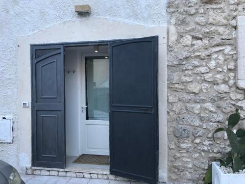 an open door to a building with a stone wall at Romeus al Fortino dimora sul mare in Vieste