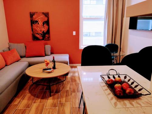 a living room with a couch and a table with fruit on it at Urban Oasis Aparthotel in Cape Town