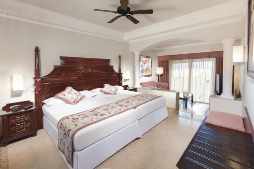 a bedroom with a large bed with a ceiling fan at Riu Palace Las Americas - All Inclusive - Adults Only in Cancún