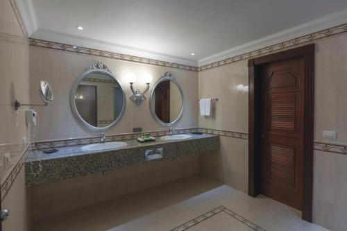 a bathroom with two sinks and two mirrors at Riu Palace Las Americas - All Inclusive - Adults Only in Cancún