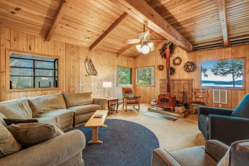 a living room with couches and a wood ceiling at Owl Lane Home in Orcas