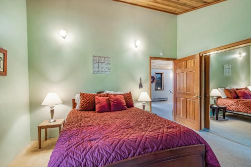 a bedroom with a bed with a purple comforter at Owl Lane Home in Orcas