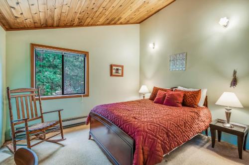 a bedroom with a bed and a chair and a window at Owl Lane Home in Orcas