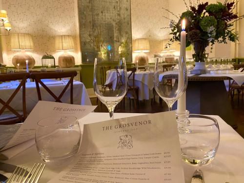 a table with two wine glasses on top of it at The Grosvenor Stockbridge in Stockbridge