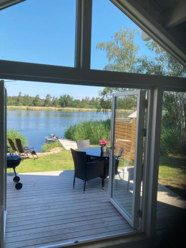 a screened porch with a table and a view of a lake at Strandstugan, Solviken in Rockneby