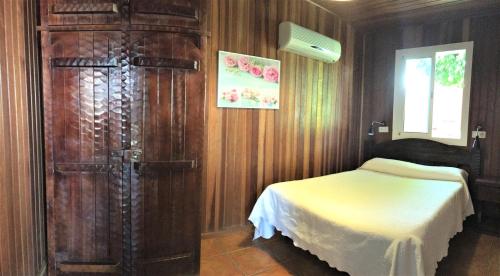 a bedroom with a bed and a large wooden cabinet at Casa Inmaculada Cabañas Mini Complejo Entero in Salobre