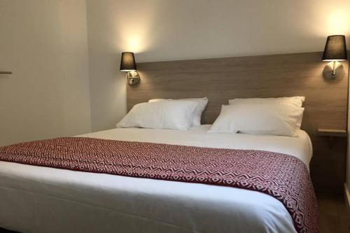 - un grand lit dans une chambre d'hôtel avec 2 lampes dans l'établissement Sweet home, à Saint-Médard-en-Jalles