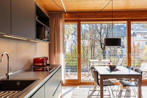 a kitchen with a table with chairs and a dining room at Kronplatz LOFT Bruneck in Brunico