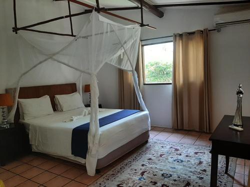 a bedroom with a bed with a canopy at LEMON BEACH LODGE Vilankulo in Vilanculos