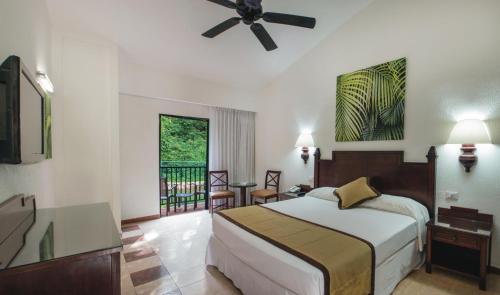 普拉亞德爾卡曼的住宿－Riu Lupita - All Inclusive，一间卧室配有一张床和吊扇