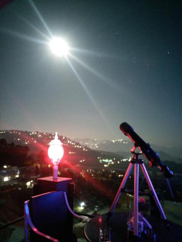 a telescope sitting on top of a mountain at night at Hotel Kasauli Regency Stags Not Allowed in Kasauli