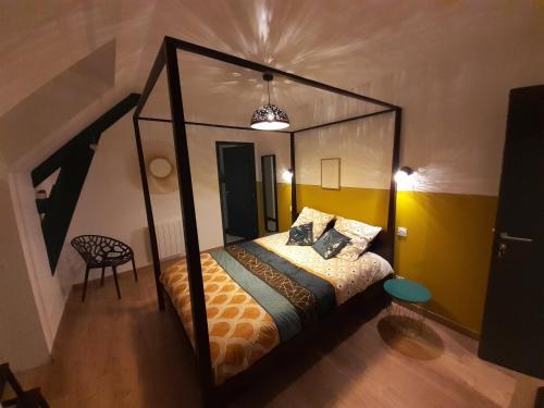 Un dormitorio con una cama con dosel en una habitación. en Chambres d`hôtes Domaine des Haies, en Dol-de-Bretagne