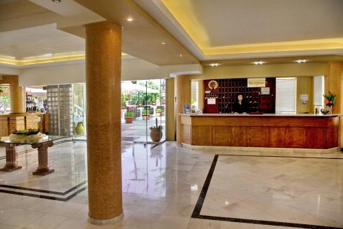 a lobby with a bar in the middle of a building at Jo An Beach Hotel in Adelianos Kampos