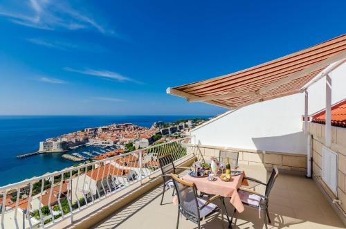 balcón con mesa, sillas y vistas al océano en Apartments Cicko en Dubrovnik