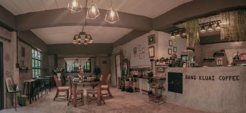 ein Restaurant mit einem Tisch und Stühlen in einem Raum in der Unterkunft Baan Bang Kluai Resort บ้านบางกล้วย รีสอร์ท in Surat Thani