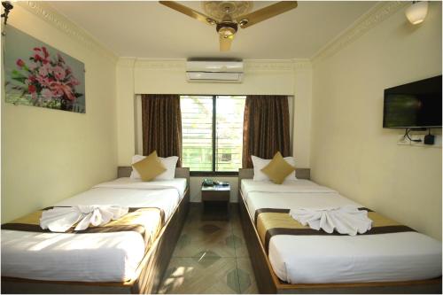 מיטה או מיטות בחדר ב-Apples Balaji Inn