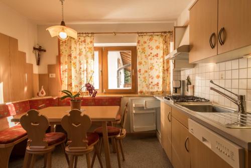 a kitchen with a table and chairs and a sink at Ferienwohnung Sella Seis in Siusi