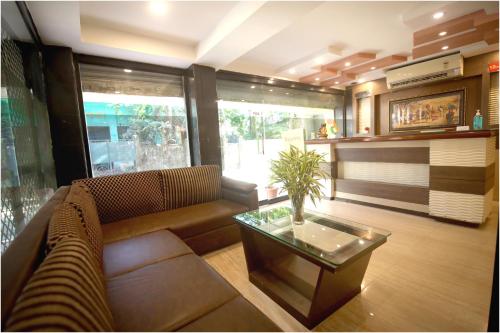 uma sala de estar com um sofá e uma mesa de centro em Apples Balaji Inn em Siliguri