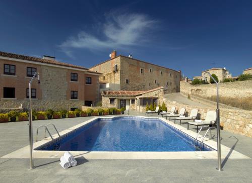 
a house with a pool and a tennis court at Parador de Trujillo in Trujillo

