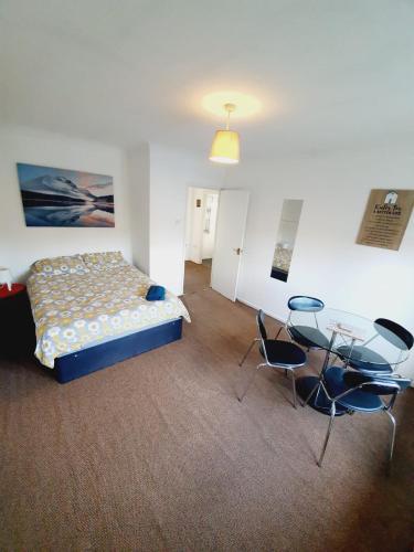a bedroom with a bed and a table and chairs at 2 Bedroom Rayleigh Apartment in Rayleigh