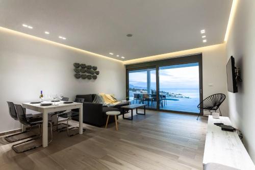 uma sala de estar com uma mesa de jantar e vista para o oceano em Executive Rhodes Villa Villa Gaia Private Pool 3 Bedrooms Lindos em Lindos