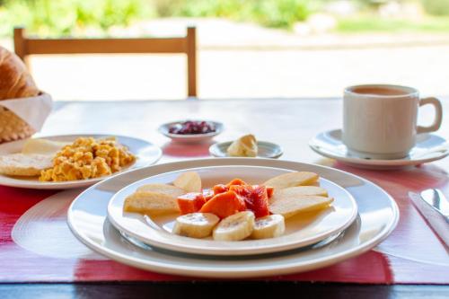 a table with plates of food and a cup of coffee at Villa Patty in Tibasosa