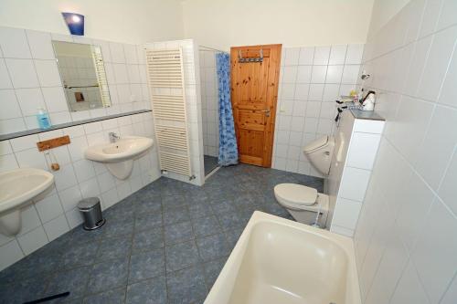 a bathroom with two toilets and a sink and a tub at Hof Brinker - Bauernstube in Boiensdorf