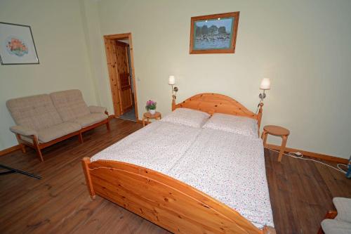 a bedroom with a wooden bed and a couch at Hof Brinker - Bauernstube in Boiensdorf