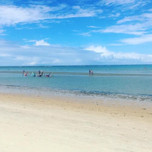 a group of people in the water at the beach at Flor de Limão Hotel Boutique in Coroa Vermelha