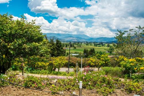 a garden with flowers and mountains in the background at Villa Patty in Tibasosa