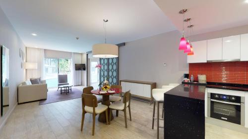 a kitchen and living room with a table and chairs at The Fives Beach Hotel & Residences - All Senses Inclusive in Playa del Carmen