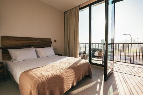 a bedroom with a bed and a balcony at Even Derech by Smart Hotels in Mitzpe Ramon