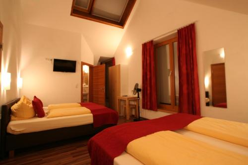 a hotel room with two beds and two lamps at Hotel Engl in Innsbruck