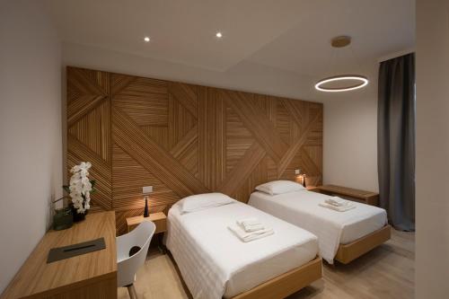 Habitación de hotel con 2 camas y pared de madera. en OPHELIA Hotel, en Cazzago San Martino