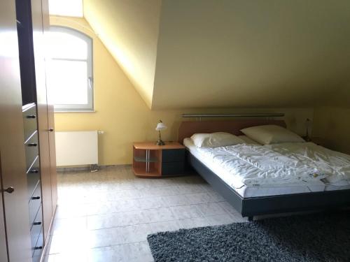 un dormitorio con una cama y una ventana en Kleine Perle, Villa Sonnegarten, en Boltenhagen