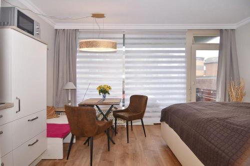 een slaapkamer met een bed en een tafel met stoelen bij Westerländer Nest in Westerland