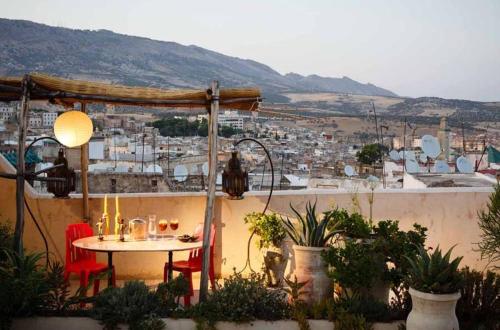 una mesa en un balcón con vistas a la ciudad en Riad Idrissy, en Fez