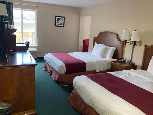 a hotel room with two beds and a flat screen tv at Hometown Inn Indian River in Indian River
