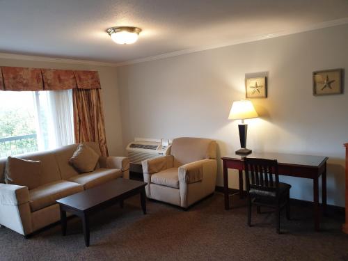 a living room with a couch and chairs and a table at Riverland Inn & Suites in Kamloops