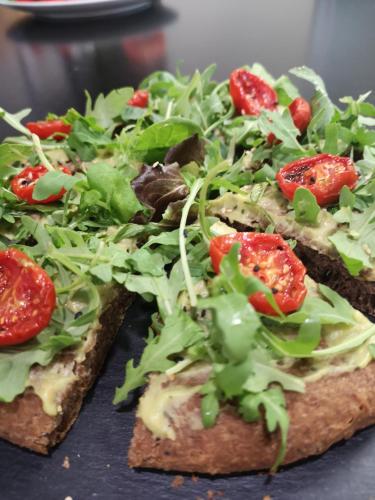 two slices of bread with tomatoes and greens on it at Mitico Hotel & Natural Spa in Bologna