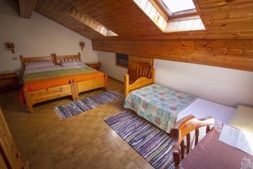 a attic room with two beds and a window at Albergo Stella in Cavalese