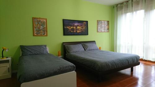 2 camas en una habitación con paredes verdes en B&B La Moka Verona, en Verona