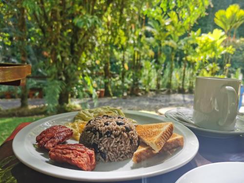 a plate of breakfast food on a table with a cup at Recreo Verde Hot Springs & Spa in Marsella