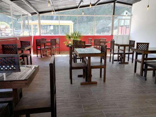 a restaurant with wooden tables and chairs and red walls at Hostal & Spa Casa Real in Baños