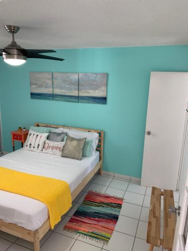 a bedroom with a bed with a blue wall at Blue Leaf by the Sea in Luquillo